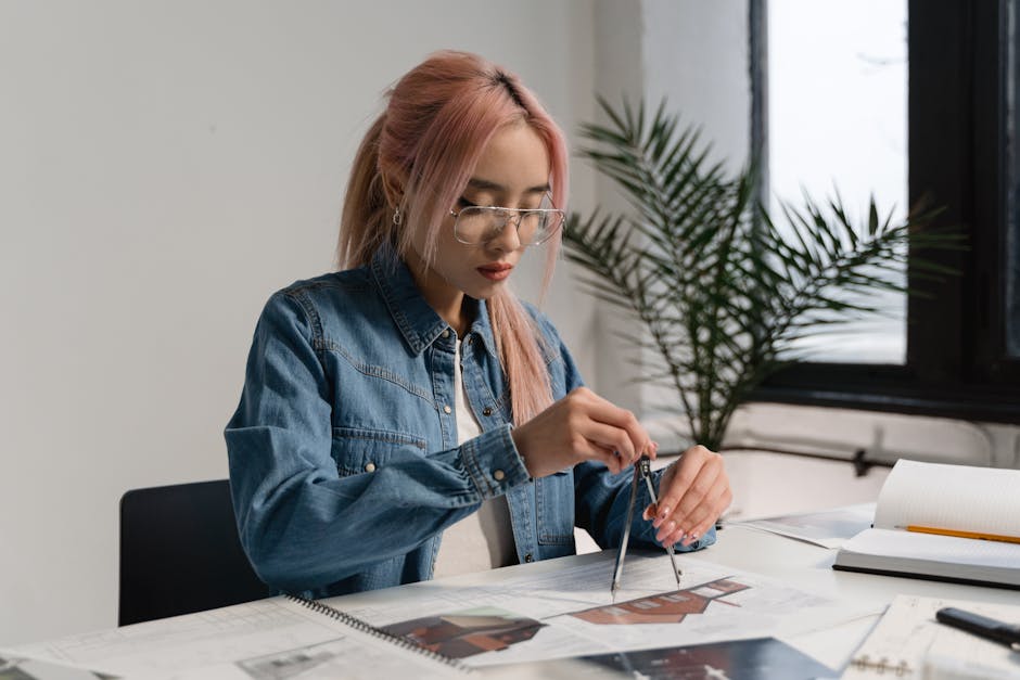 A young professional architect working on designs at a modern office desk.